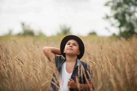 Boy looking up in a tall grass field outdoors. Foto stock