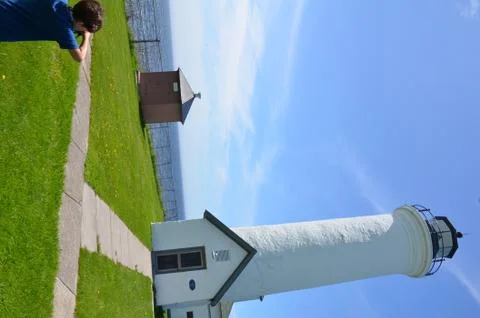 Boy looking at tall lighthouse building and blue sky Tibbetts Point Stock Photos