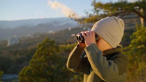 Boy looking through binoculars around while in nature Stock Footage 263851989