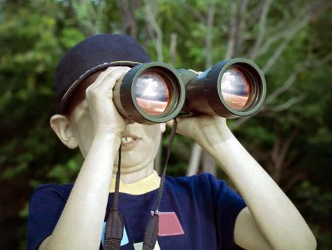 Boy looking through binoculars at the explosion Stock Photos