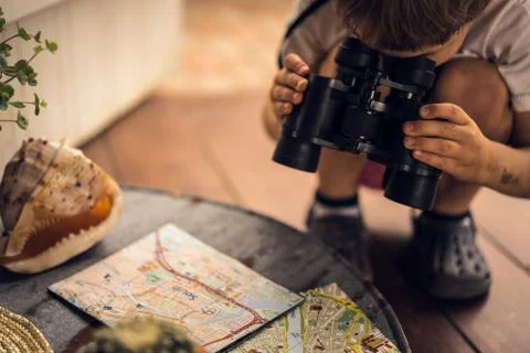Boy looking through binoculars map on the table Stock Photos