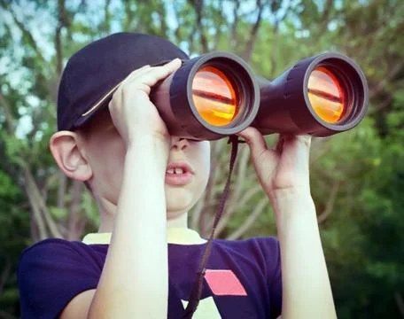 Boy looking through binoculars Stock Photos