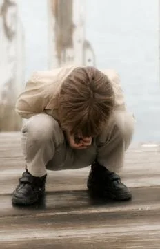 Boy looking through cracks in the pier Stock Photos