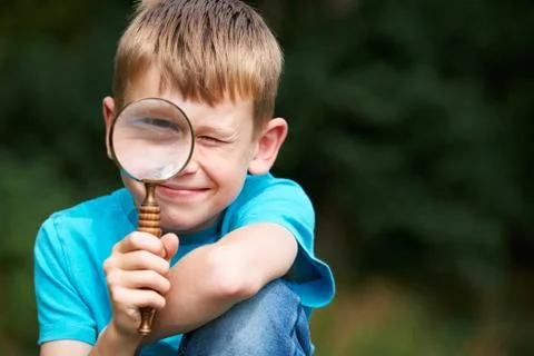 Boy Looking Through Magnifying Glass With Magnified Eye Stock Photos