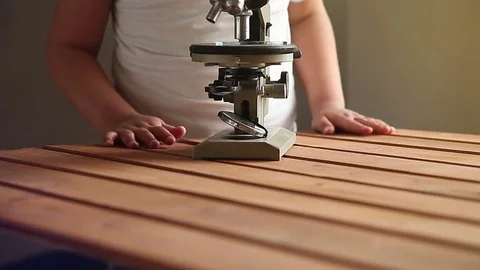 The boy is looking through a microscope Stock Footage 75559174