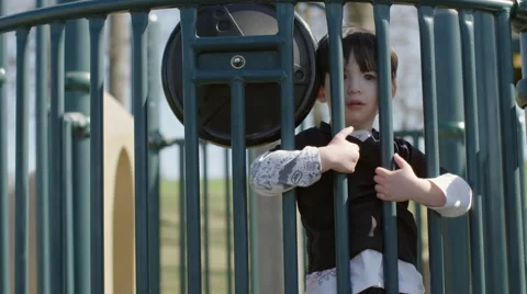 Boy looking through railings at a park 4K Stock Footage 49645199