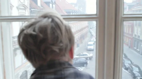 BOY LOOKING THROUGH WINDOW ON THE STREET Stock Footage 68755891