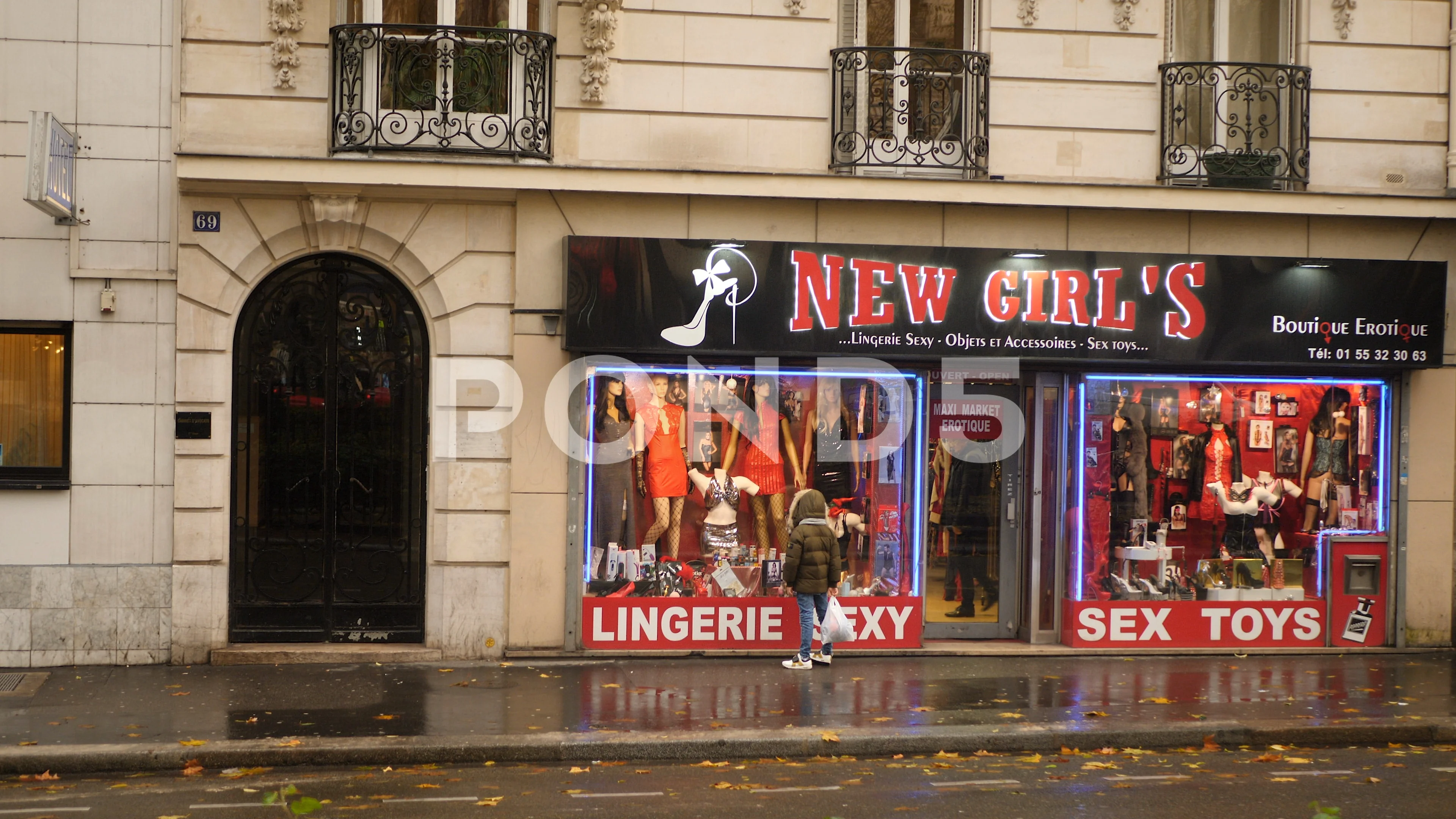 Boy looking in the window of sex shop. Paris, France.