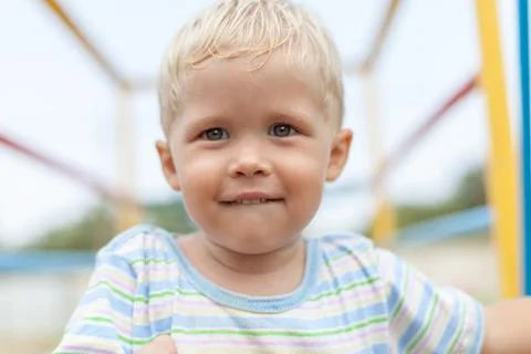 Boy looks at the camera biting his lip with narrow depth of field Stock Photos