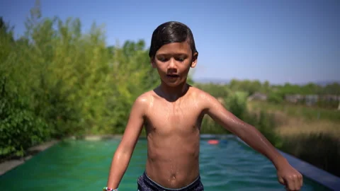 Boy Looks at Camera Before Jumping Backward Into the Pool Stock Footage 343359437