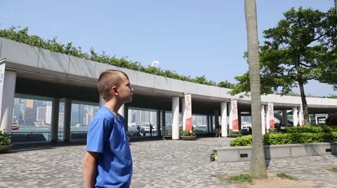 Boy looks at the Clock Tower on the Kowloon Public Pier in Hong Kong Stock Footage 50367962