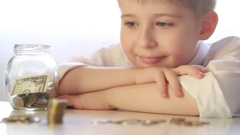  boy looks at coins Stock Footage 70136294