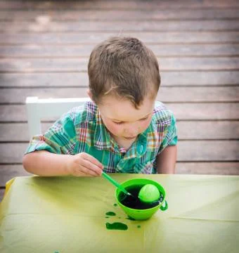 Boy Looks at His Easter Egg in the Green Dye Stock Photos