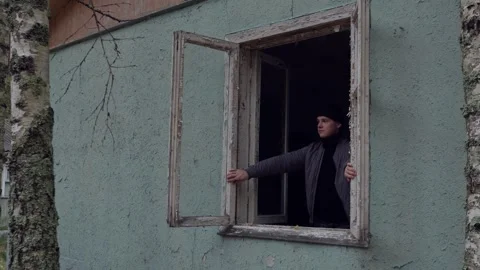 Boy looks out the window and closes the frames from the inside. Stock Footage 287152353