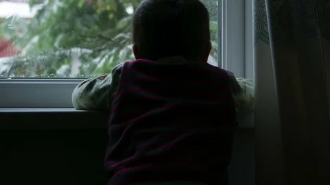 Boy looks out the window Stock Footage 75811960