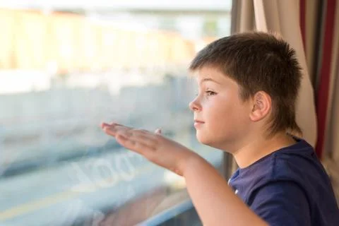 Boy looks out the window on train Stock Photos