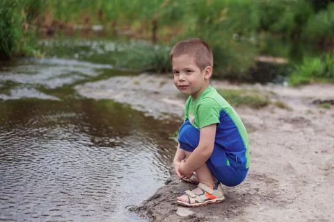 The boy looks at the river Stock Photos