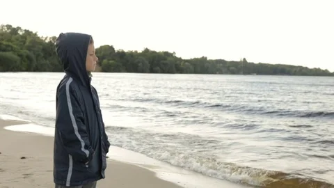 A boy looks at the sea, side view Vidéo 76940602