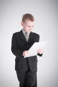 Boy looks at the stack of papers Stock Photos