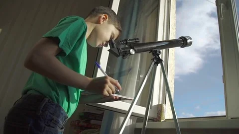 The Boy Looks in the Telescope Through an Open Window Video stock 70065589