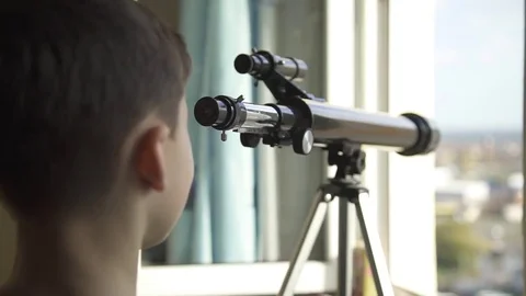 The Boy Looks in the Telescope Through an Open Window Video stock 70065889