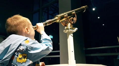 Boy looks through a telescope Stock Footage 98561696