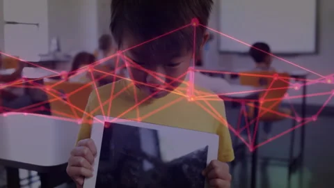 Boy lowering tablet revealing face as red wireframe receding in school with Stock Footage 311506114