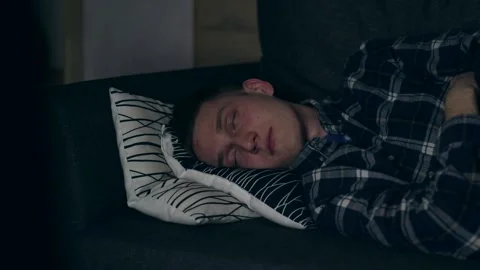 A boy lying on a bed, sleeping with working TV Stock Footage 149596678