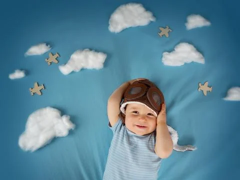 Boy lying on blanket with white clouds Stock Photos