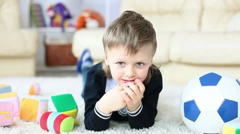Boy lying on the carpet in the room Stock Footage 10686889