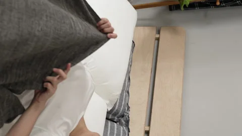 Boy lying down to go back to sleep after sitting Stock Footage 229621690