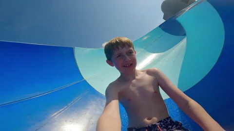 Boy Lying Down While Sliding On Water Sl... | Stock Video | Pond5