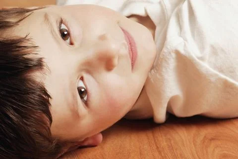 Boy Lying On The Floor Stock Photos