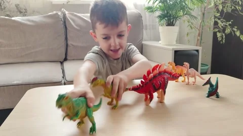 A boy lying on the floor plays with his favorite toys, bright figures of Stock Footage 272180514