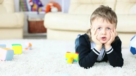 Boy lying on the floor poses faces Stock Footage 10686894