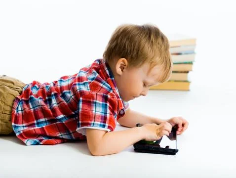 Boy lying on the floor with tablet computer Stock Photos
