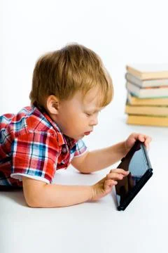 Boy lying on the floor with tablet computer Stock Photos