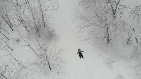 Boy lying in fresh snow moving arms and legs and making snow angles 스톡 동영상 122611617
