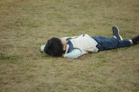 Boy lying on the grass Stock Photos