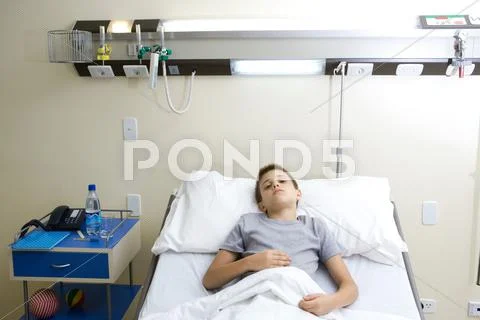 Boy Lying In Hospital Bed, Holding Stomach