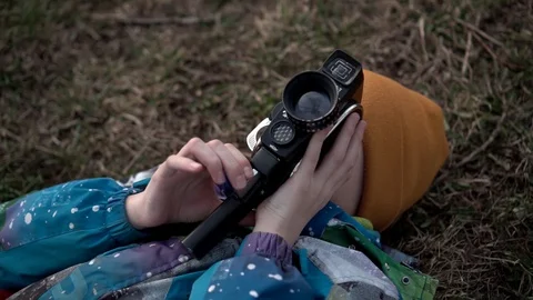 The boy is lying with a movie camera in his hands on the grass Stock Footage 128330166
