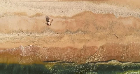 Boy lying on sand and makes an angel on a sandy beach, moving his arms and legs Stock Footage 175461542