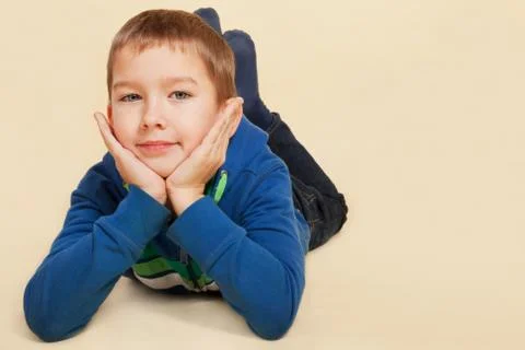 Boy lying, smiling and looking into camera. Stock Photos