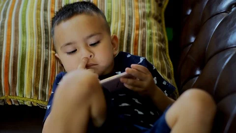 The boy lying on the sofa and enjoy with smartphone Stock Footage 92194586