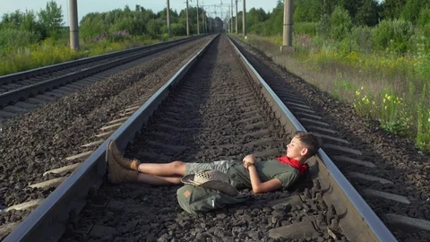 Boy Lying On Train Rails Video stock 79497595