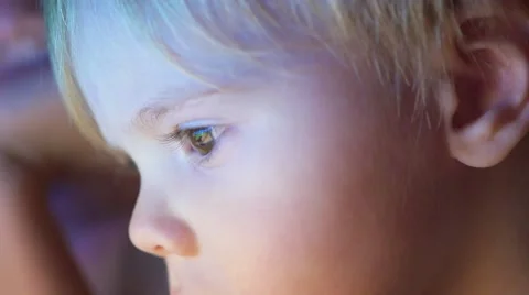 Boy lying under blanket and watching cartoons on touch pad closeup face Vidéo 68369855