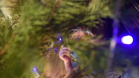Boy lying under the Christmas tree and hang Christmas decorations Video stock 118721978