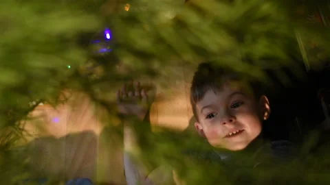 Boy lying under the Christmas tree and hang Christmas decorations Stock-Footage 120017878