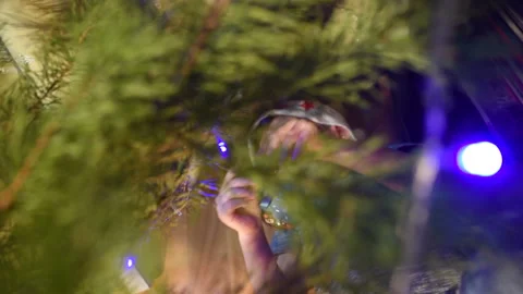 Boy lying under the Christmas tree and hang Christmas decorations Video stock 120017915