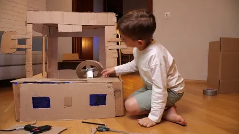 A boy made a cardboard car, a boy plays with a cardboard car Stock Footage 254706378